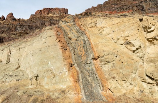 Basaltic dike intruding volcanic mudflow deposits, eastern Oregon. Note the baked and altered edge of the country rock.